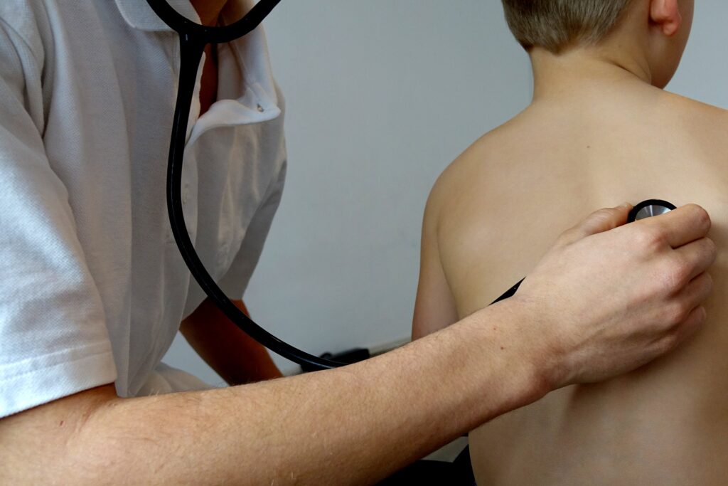 Läkare som auskulterar lungorna på ett barn